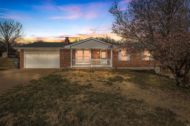 single story home with brick siding, a front lawn, a porch, a garage, and driveway