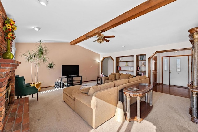 carpeted living area with a ceiling fan, lofted ceiling with beams, arched walkways, a fireplace, and baseboards