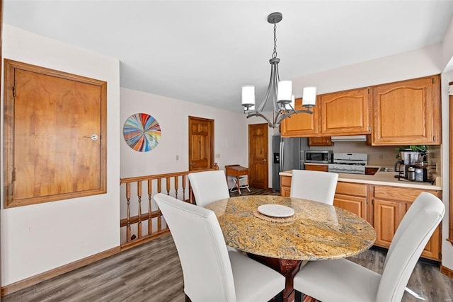 dining space featuring baseboards, dark wood-style flooring, and a chandelier