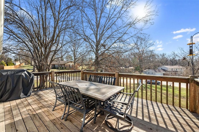 wooden deck featuring grilling area, outdoor dining space, and a residential view