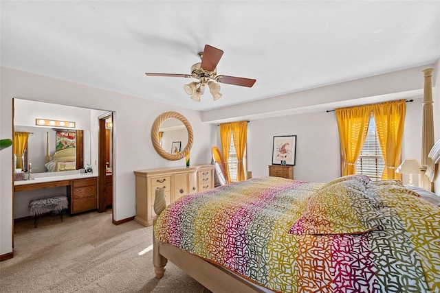 carpeted bedroom with baseboards, ceiling fan, and ensuite bathroom