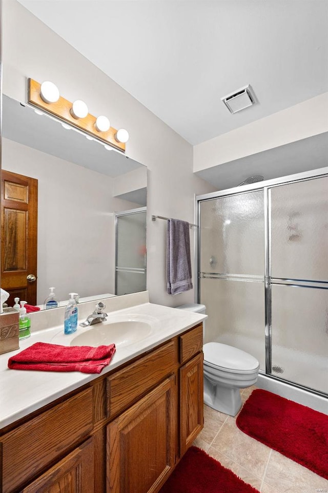 bathroom featuring tile patterned floors, visible vents, toilet, a stall shower, and vanity