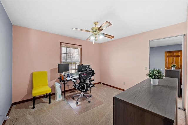 carpeted office with baseboards and a ceiling fan