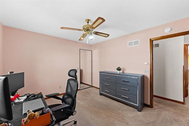 home office with visible vents, light colored carpet, and ceiling fan