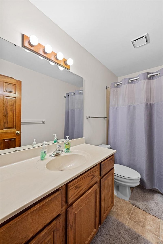 bathroom with vanity, toilet, and visible vents