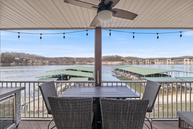 deck with beverage cooler, a ceiling fan, and a water view