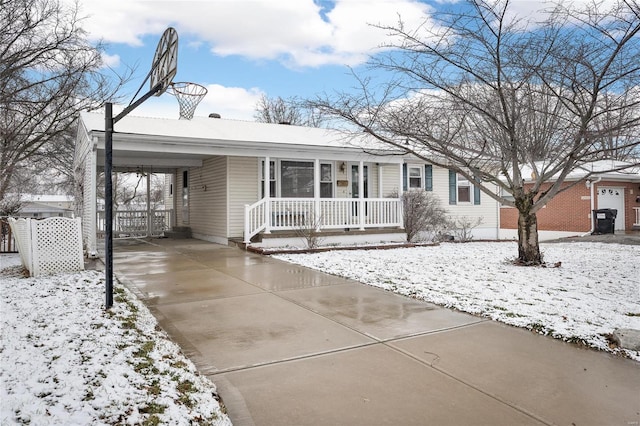 single story home featuring a carport, covered porch, and concrete driveway