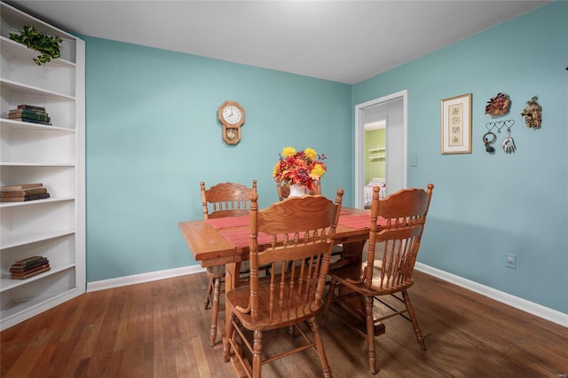 dining space featuring baseboards and wood finished floors