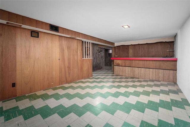 bar featuring tile patterned floors and wood walls