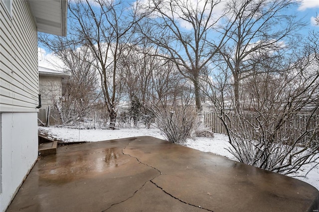 snow covered patio featuring fence