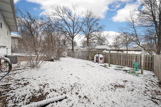 snowy yard with a fenced backyard