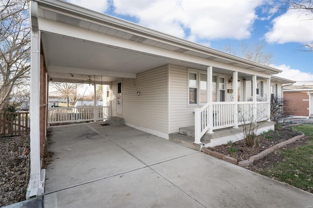 view of front of property featuring a carport, concrete driveway, fence, and covered porch