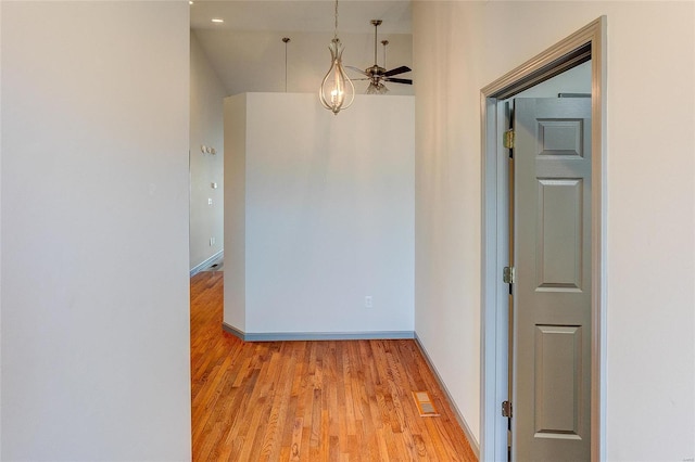 corridor featuring light wood-style floors, visible vents, and baseboards