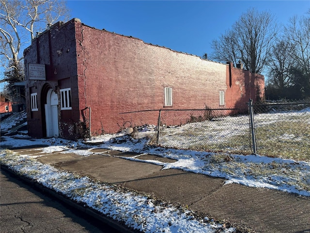 view of snowy exterior with fence