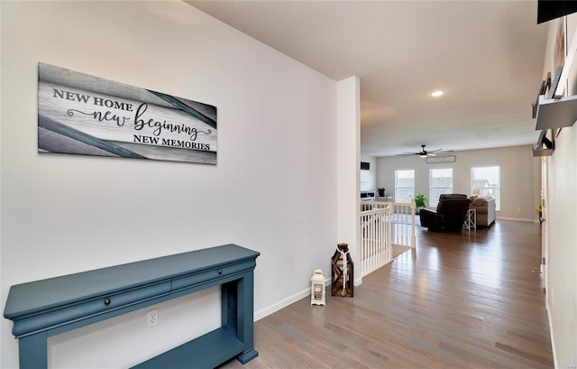 corridor featuring an upstairs landing, baseboards, wood finished floors, and recessed lighting