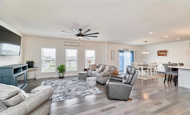 living room with recessed lighting, a healthy amount of sunlight, baseboards, and wood finished floors