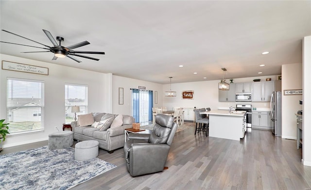 living room featuring recessed lighting, wood finished floors, baseboards, and ceiling fan