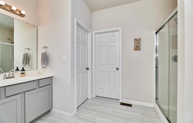 full bath with vanity, visible vents, a stall shower, and baseboards