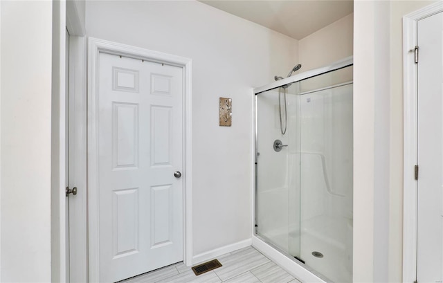 full bathroom featuring visible vents, baseboards, and a shower stall