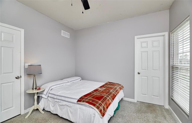 carpeted bedroom with visible vents, ceiling fan, and baseboards