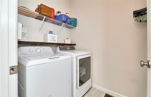 laundry area featuring laundry area, washing machine and dryer, and baseboards