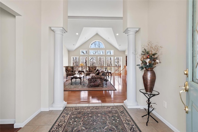 foyer entrance with tile patterned floors and decorative columns