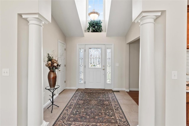 entrance foyer with decorative columns, baseboards, and light tile patterned floors