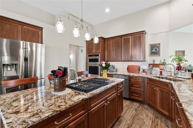 kitchen featuring a sink, stainless steel appliances, and light stone countertops