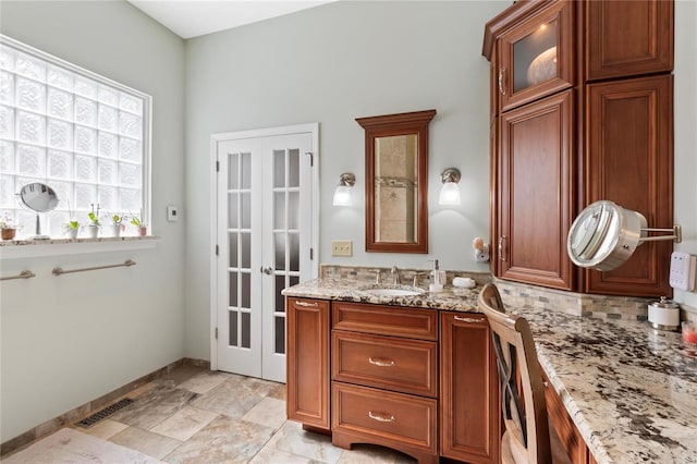 bathroom with visible vents, backsplash, baseboards, french doors, and vanity