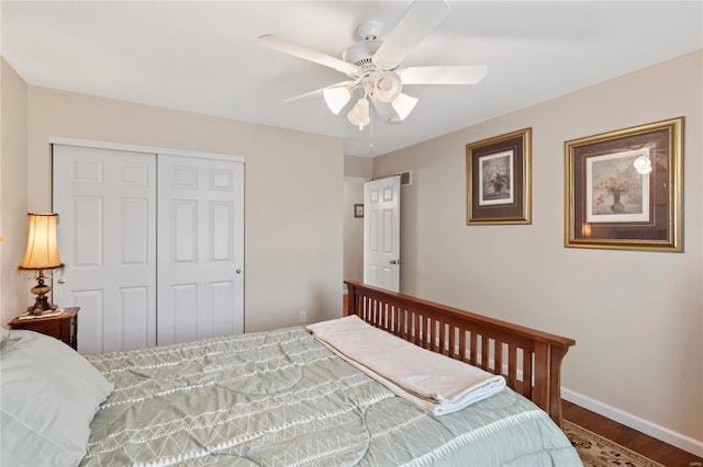 bedroom with visible vents, baseboards, wood finished floors, a closet, and a ceiling fan