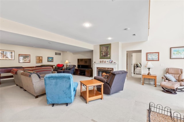 living room featuring visible vents, recessed lighting, a fireplace, baseboards, and light colored carpet