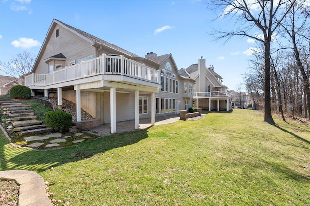 back of house featuring stairs, a lawn, and a wooden deck