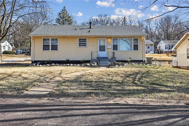 view of front of house with a front lawn and a shingled roof