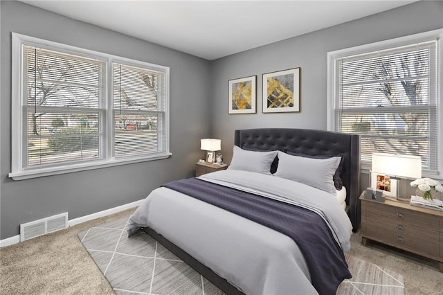 carpeted bedroom featuring visible vents and baseboards