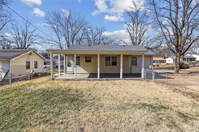 view of front of house with a front yard, fence, covered porch, and a shingled roof