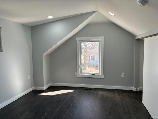 bonus room with dark wood-type flooring, lofted ceiling, baseboards, and recessed lighting