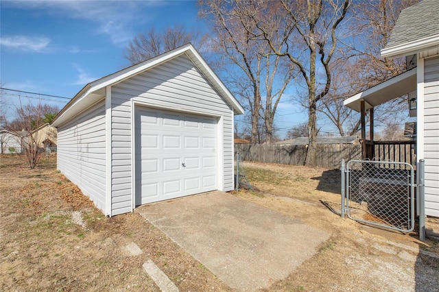 detached garage with central air condition unit, driveway, and fence