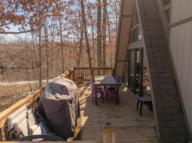 wooden terrace featuring outdoor dining area and grilling area