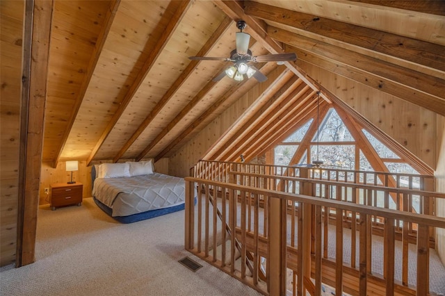 bedroom with wooden walls, visible vents, lofted ceiling with beams, wooden ceiling, and carpet flooring