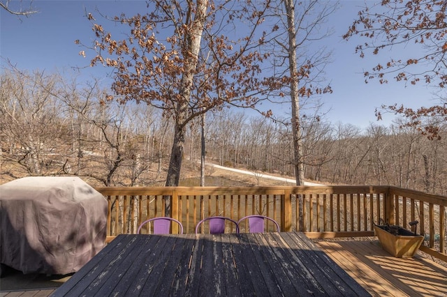 wooden deck with area for grilling and outdoor dining space