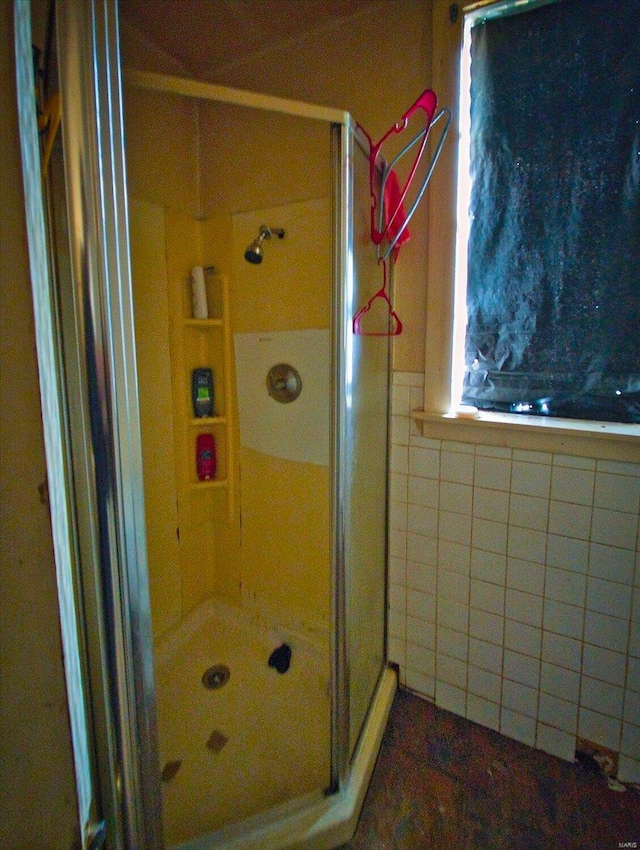 bathroom featuring a stall shower and tile walls