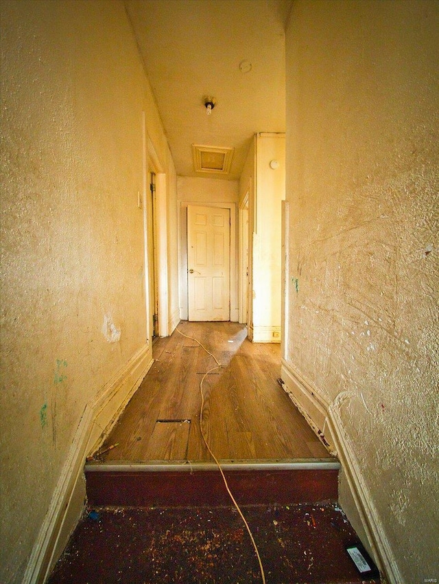 hall with attic access and wood finished floors