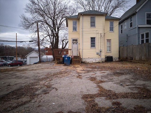 view of front of property featuring central AC, an outdoor structure, and fence