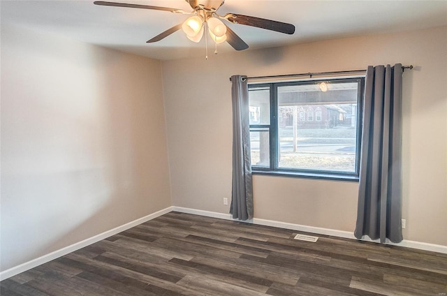 empty room with ceiling fan, visible vents, baseboards, and dark wood finished floors