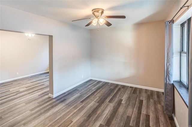 spare room featuring ceiling fan, baseboards, and wood finished floors