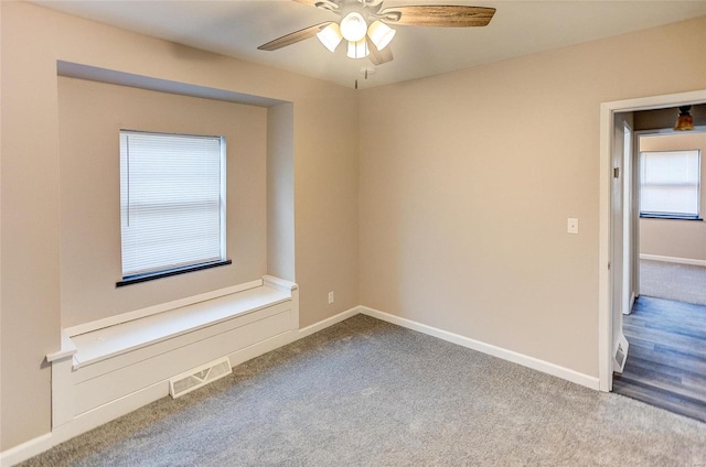 empty room with visible vents, carpet floors, and baseboards