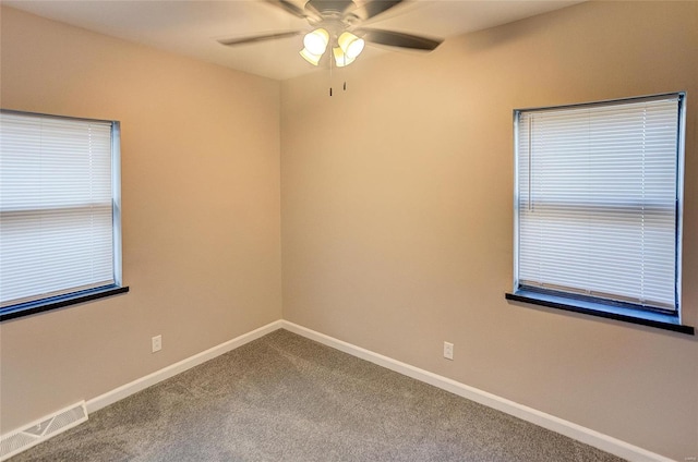 spare room with visible vents, baseboards, a ceiling fan, and carpet flooring