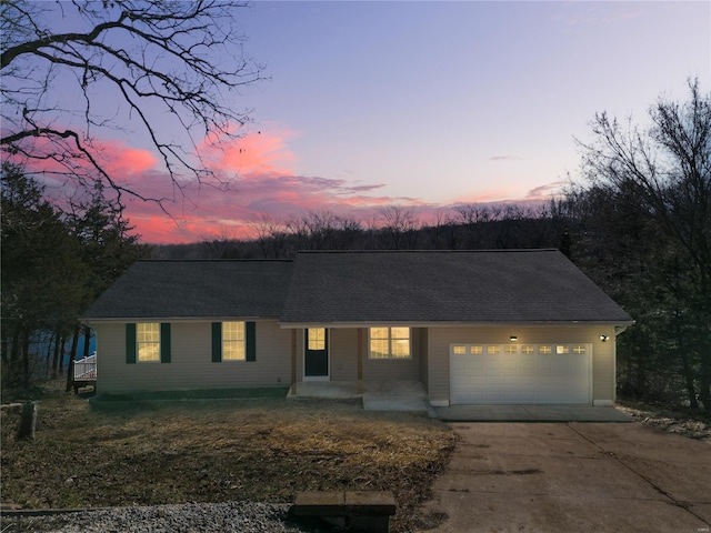 view of front of house featuring a shingled roof, driveway, and an attached garage