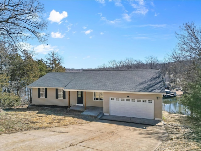 single story home featuring a garage, driveway, a shingled roof, and covered porch