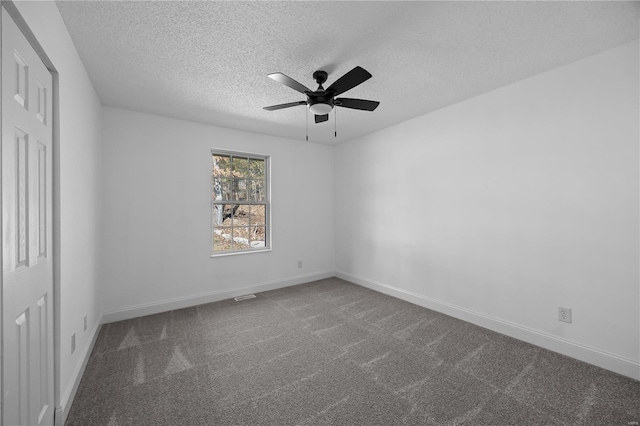 carpeted spare room featuring a textured ceiling, a ceiling fan, and baseboards